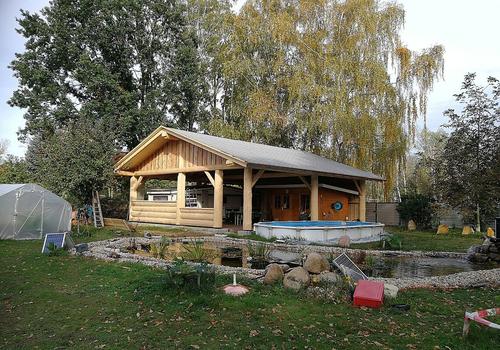 Ein 10x10m Carport in Naturstammbauweise mit Theke