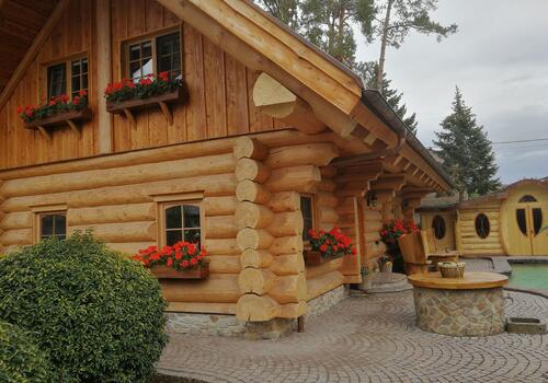 Naturstammhaus "Whitehorse Lodge" - Traufseite mit Hauseingang