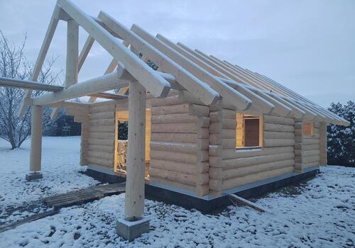 Halbstamm Blockhaus Whitefish Creek II_Ansicht Blockhaus mit Vordach.jpg