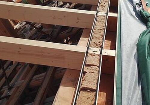 KvH-Sparren werden montiert. Die Stellbrett-Zwischenräume werden isoliert.