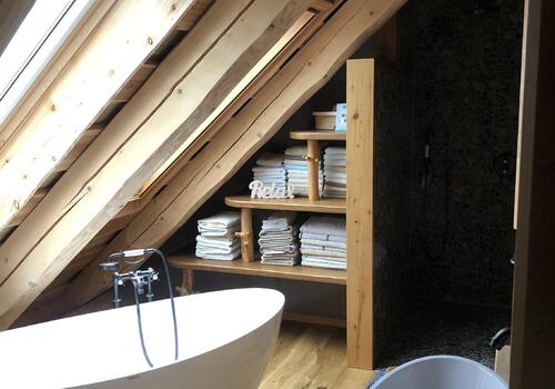 Freistehende Badewanne in einem Naturstammhaus - Bad im OG