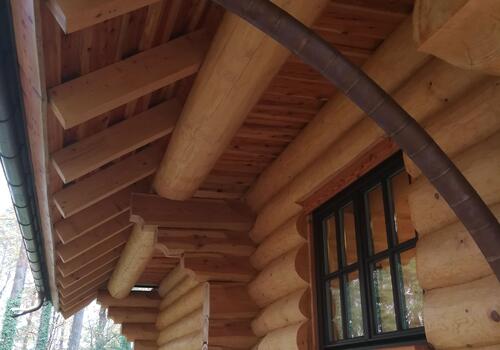 Eine außenliegende Fußpfette an einem Blockhaus schafft im Obergeschoss mehr Platz