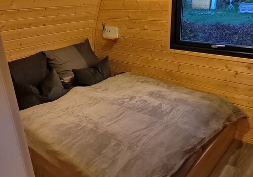 Doppelbett im Schlafzimmer eines TinyHaus