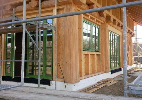 Ausfachung der Wände beim Post & Beam Blockhaus wahlweise mit Naturstamm oder, wie hier, als Ständerwerkausfachung