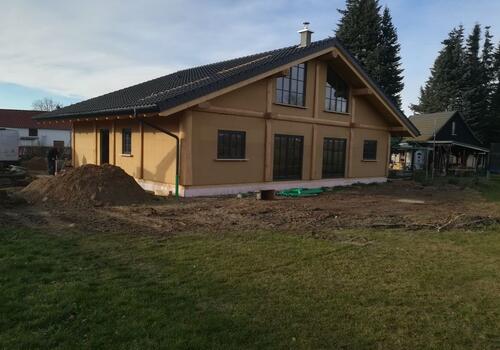 Bei diesem Post & Beam Blockhaus gibt es keine geblockten Wände. Nur Säulen, Rähm, Deckenbalken und Pfetten sind in Naturstamm.
